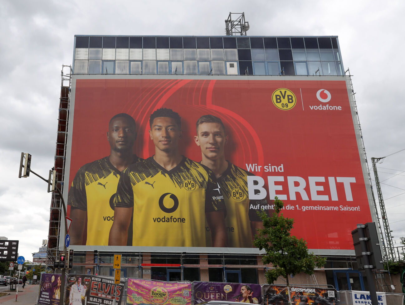 22082025-deutschland-nrw-sport-fussball-bundesliga-831224451 22.08.2025, Deutschland, NRW, Sport, Fussball-Bundesliga, Vereine, Sponsoren, Vodafone ist neuer Sponsor von Borussia Dortmund - auf dem Plakat sind die Spieler Serhou Guirassy, Jobe Bellingham und Nico Schlotterbeck mit den neuen Trikots abgebildet, BVB09, Deutschland *** 22 08 2025, Germany, NRW, Sport, Soccer Bundesliga, Clubs, Sponsors, Vodafone is Borussia Dortmunds new sponsor The poster shows the players Serhou Guirassy, Jobe Bellingham and Nico Schlotterbeck with the new jerseys, BVB09, Germany Copyright: xD.xKerlekin SnowfieldxPhotographyx SF220825BVBD1