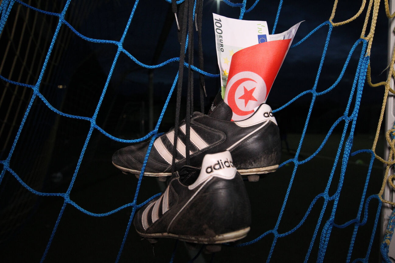 In einem Tornetz hängen Fußballschuhe. Darin sind Euro-Scheine (Spielgeld) sowie eine kleine türkische Fahne gesteckt. Symbolbild Symbolfoto Wettskandal im türkischen Fußball. Eimsbüttel Hamburg *** Soccer boots hanging in a goal net Euro bills, play money and a small Turkish flag are stuck in it Symbol image Symbol photo Betting scandal in Turkish soccer Eimsbüttel Hamburg