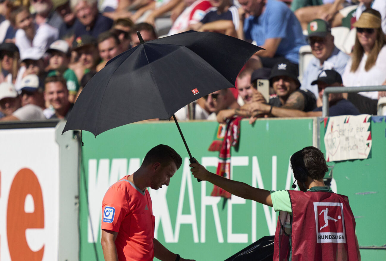 referee Daniel Schlager (SR) checks penalty, with whistle, gestures, shows, watch, individual action, Schiedsrichter, Hauptschiedsrichter, schiri, Pfeiffe, Pfiff, in action in the match FC AUGSBURG - BORUSSIA MÖNCHENGLADBACH on Aug 19, 2023 in Augsburg, Germany. Season 2023 2024, 1.Bundesliga, FCA, Gladbach, matchday 1, 1.Spieltag